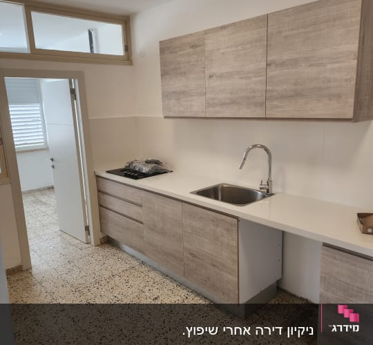 מטבח נקי עם ארונות עץ וכיור נירוסטה
